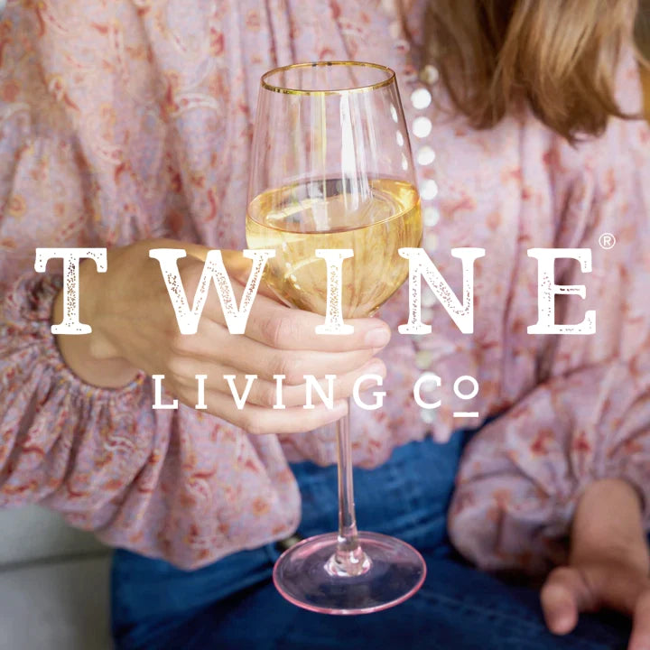 woman holding a wine glass from twine living co. logo overlay.