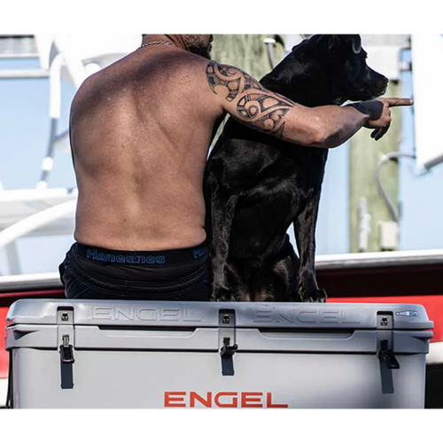 A man and dog sitting on Engel cooler.
