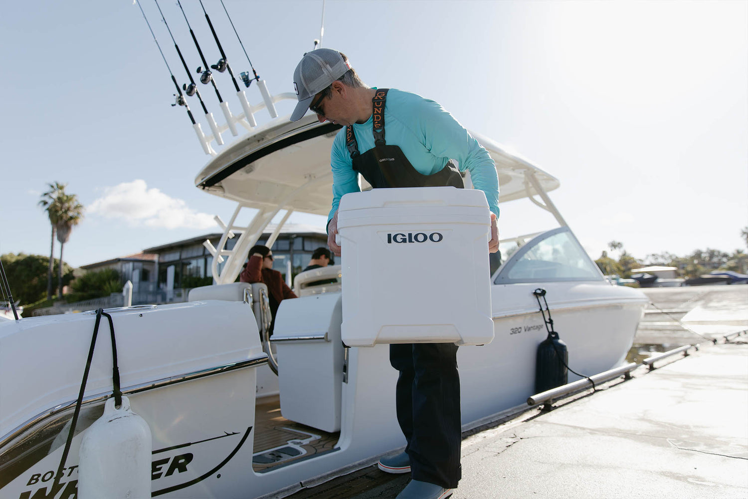 Man loading boat with white Igloo Latitude Marine 30 quart cooler