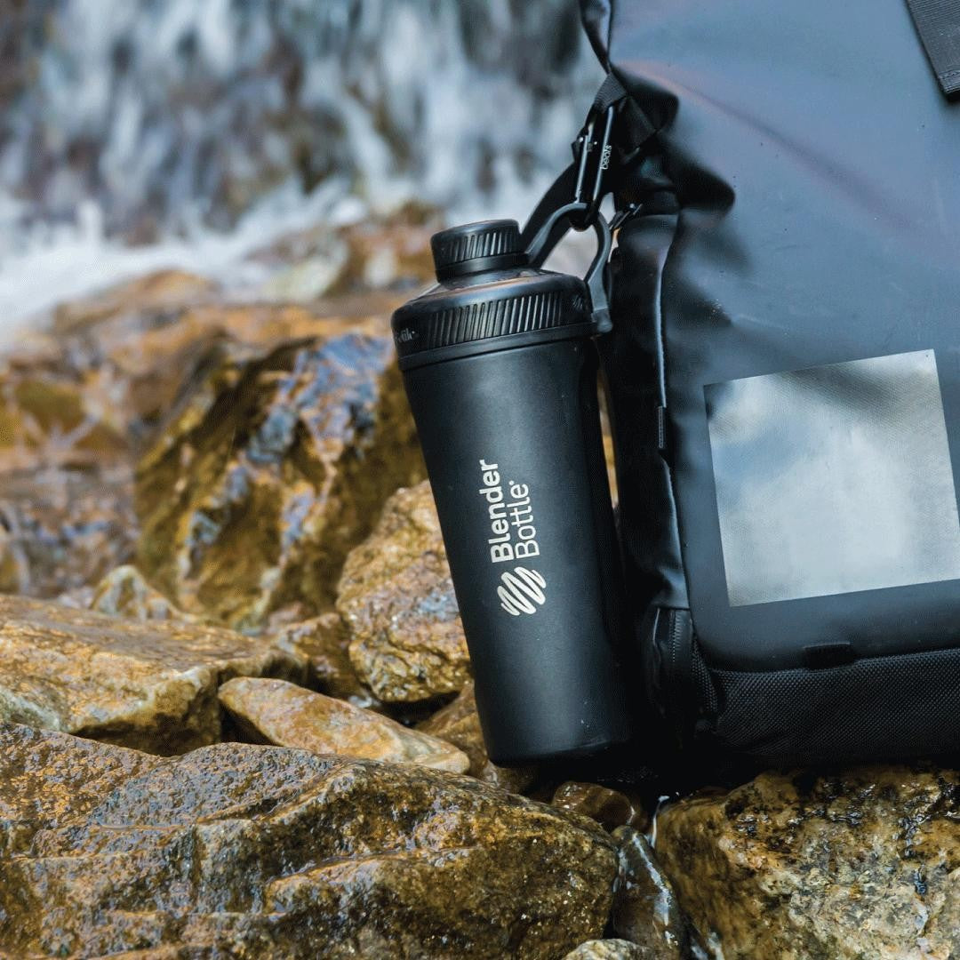 Black BlenderBottle Radian bottle hooked onto black backpack