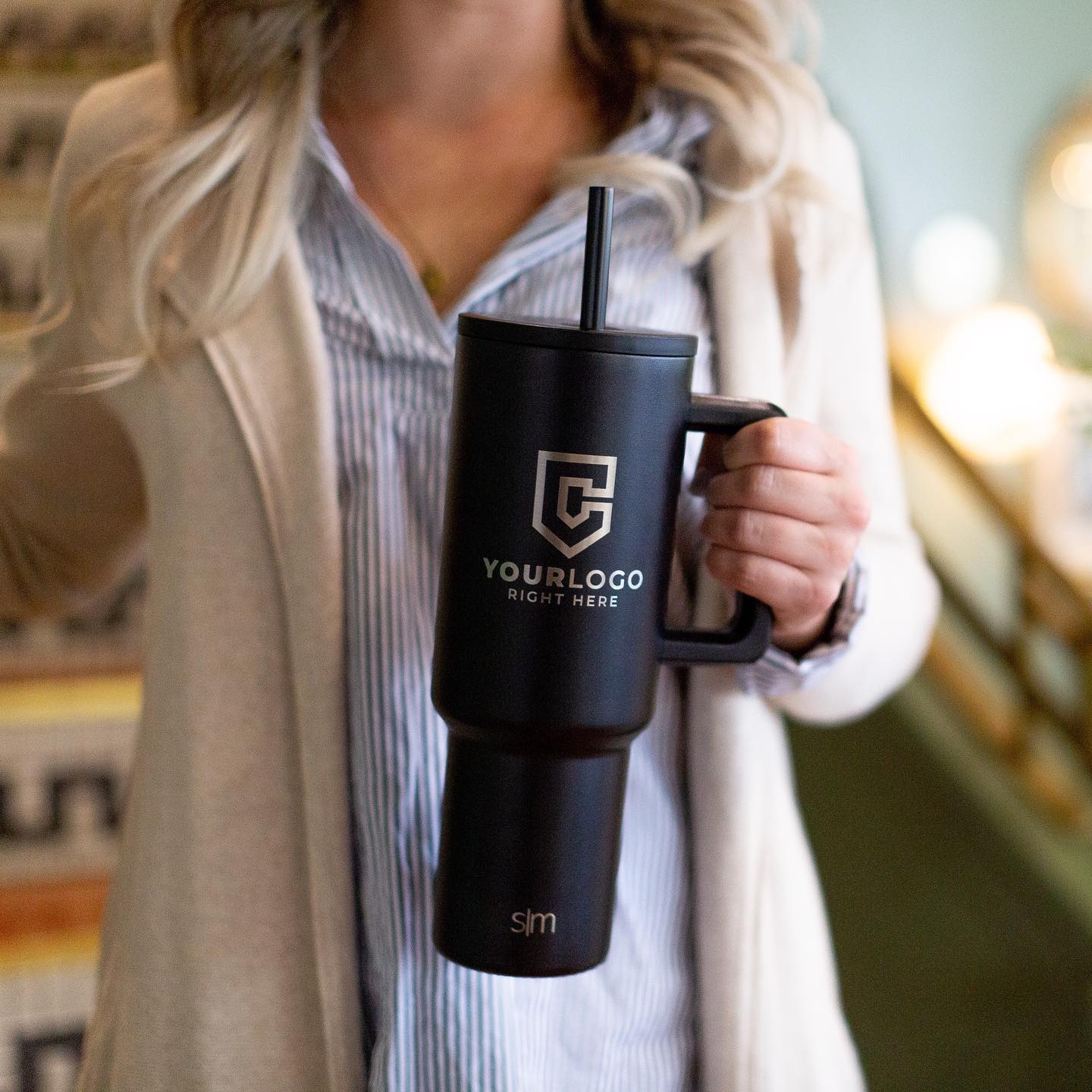 Woman holding black Simple Modern Trek Tumbler with laser engraved design