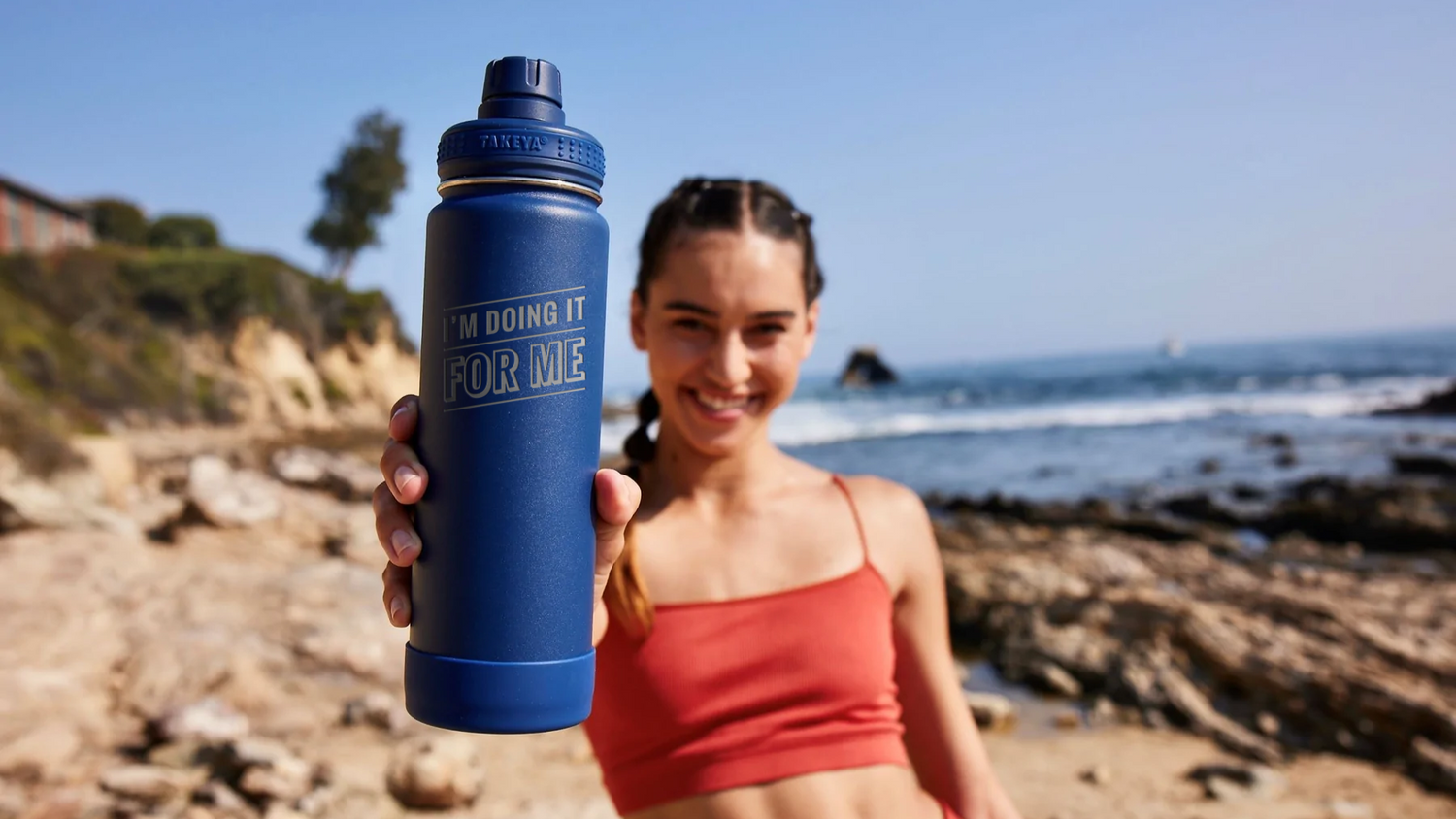 women in workout clothes wearing a takeya water bottle with "I'm doing it for me" engraved on it.