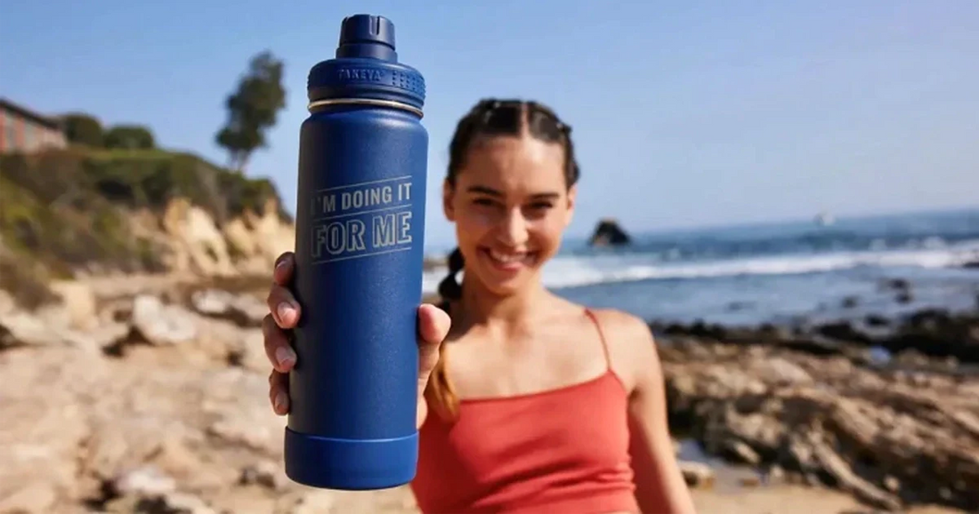 Woman holding an active stainless water bottle with personalized saying