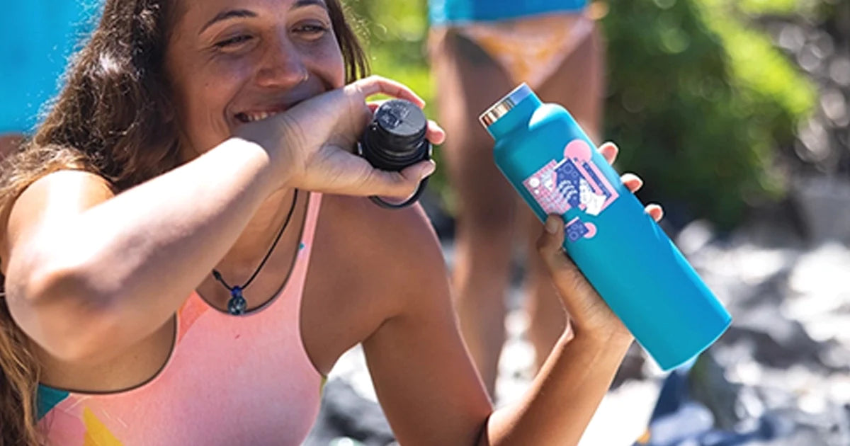 woman on beach with a green custom printed hydro flask bottle