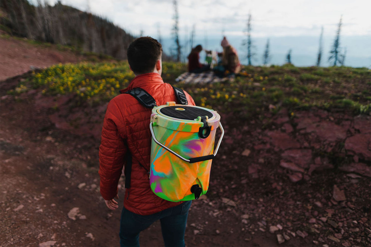 Man hiking while wearing Brumate BackTap in Rainbow Swirl