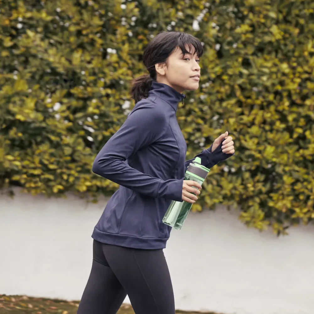 Woman jogging while using Contigo Ashland 2.0 24 oz. Bottle in Cucumber.
