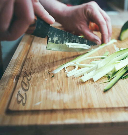 person chopping food on a personalized maple cutting board