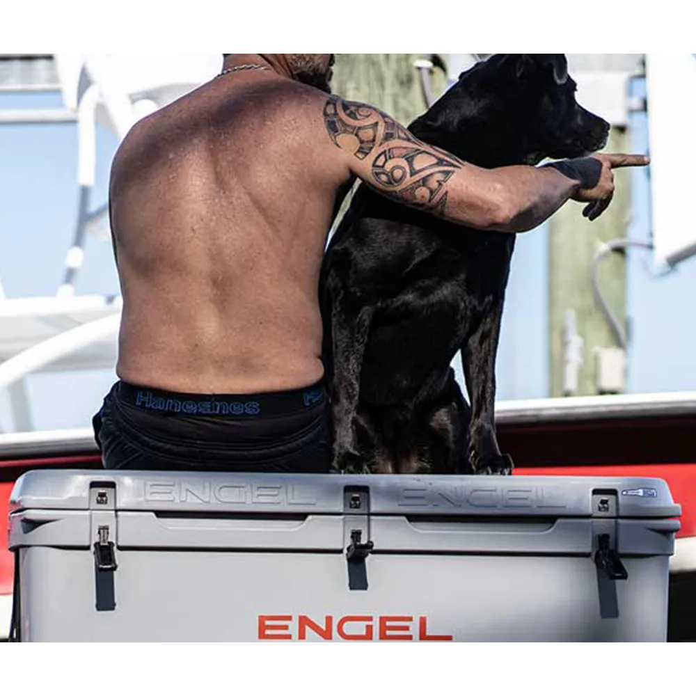 A man and dog sitting on Engel cooler.