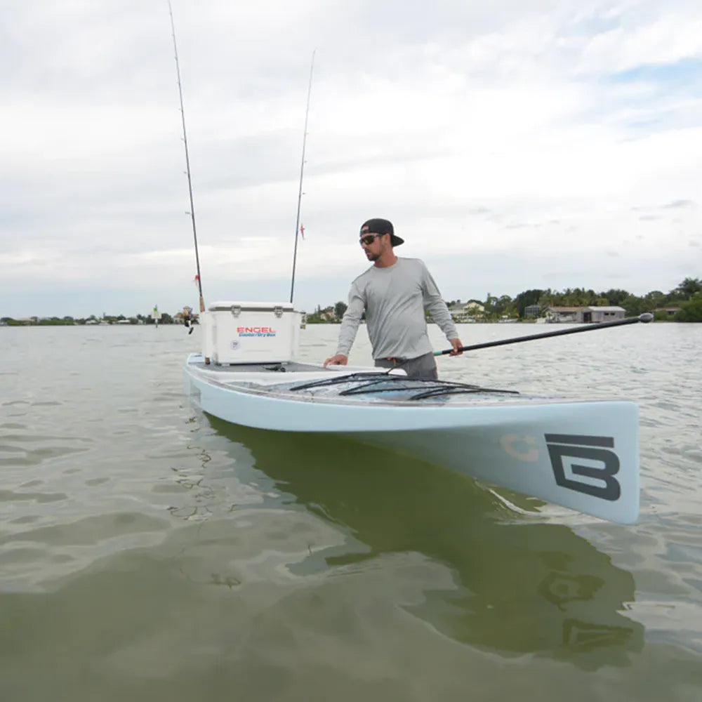 Engel 13 Quart Drybox/Cooler on sitting on the back of a kayak with fishing poles, as a man stands next to the kayak.