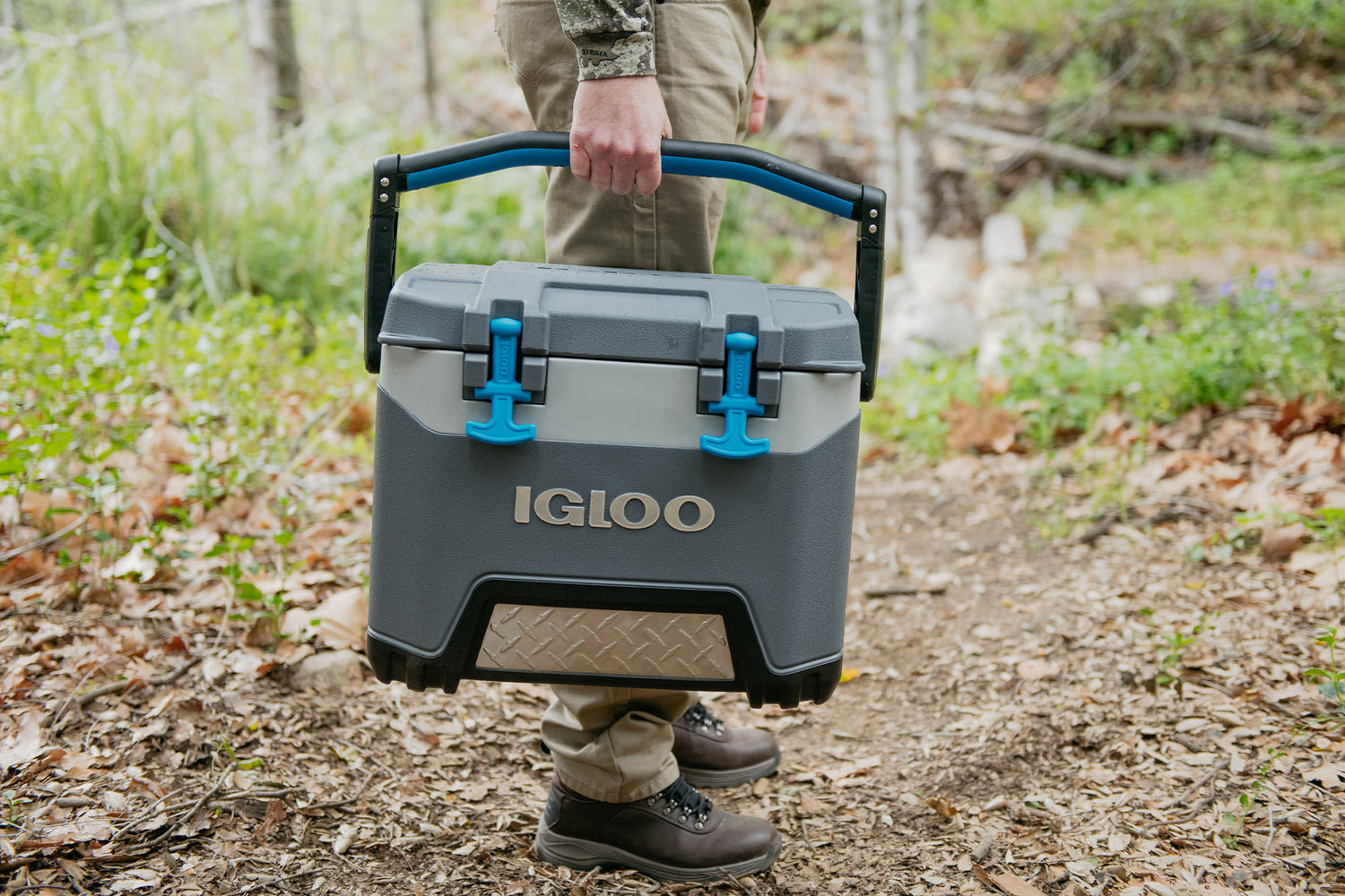 Man holding Igloo BMX 25 quart cooler in woods