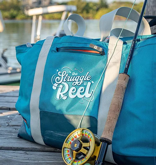 custom printed soft cooler with fishing design, sitting on a fishing pier.