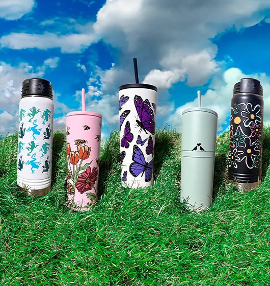 Easter themed custom printed tumblers and bottles on a grassy hill