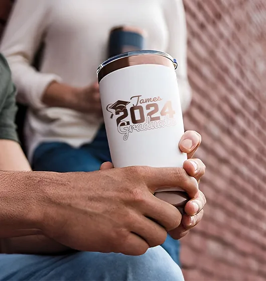 Man holding a white yeti with personalized graduation laser engraving,