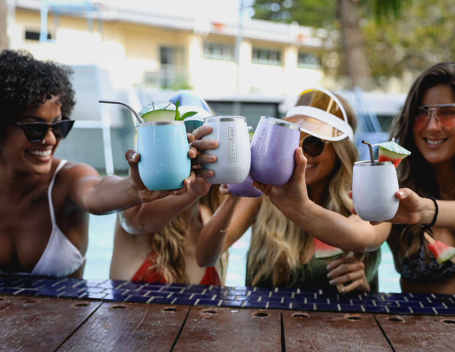 Women cheersing at a pool with brumate wine tumblers