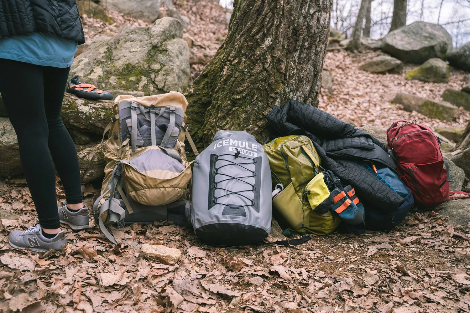 Icemule pro cooler laying on ground next to camping gear