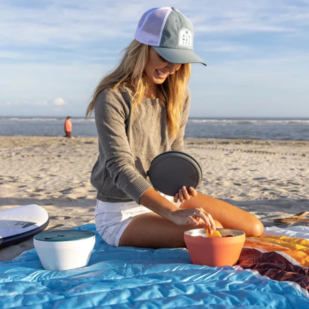 Woman at beach taking food out of Rigwa Fresh Bowl 40 oz.