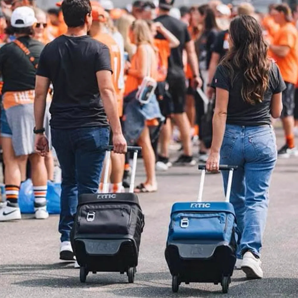 Couple wheeling RTIC Everyday Wheeled Cooler at an event.