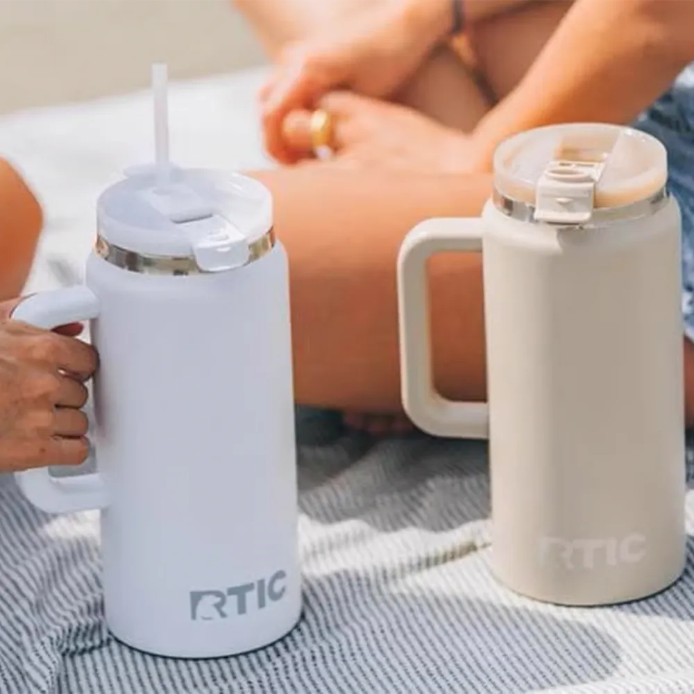 RTIC 64 oz Road Trip Tumblers on beach towel.