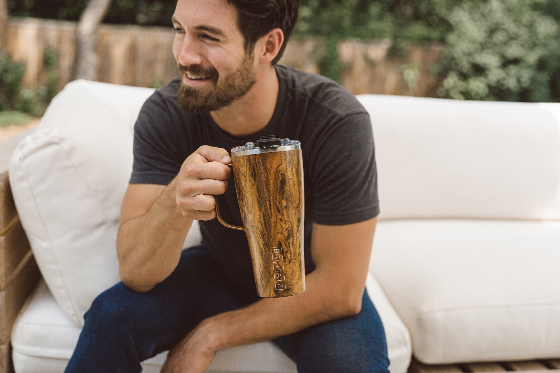 Man sitting on white couch outside with Brumate Toddy XL Mug with Wood design