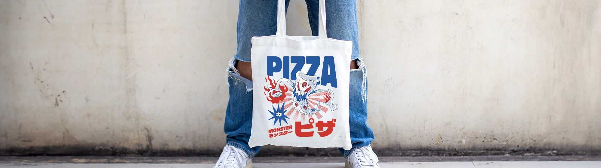 Person holding custom tote bag with printed design of a japanese pizza monster
