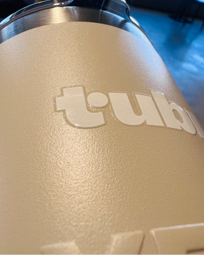 Close-up of a beige tumbler with 'tub' branding on a blurred background.  UV Printed