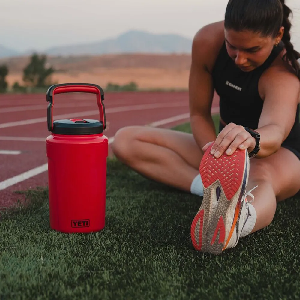 Woman stretching beside Yeti 0.5 gal Silo Jug with Magslider Straw Cap.