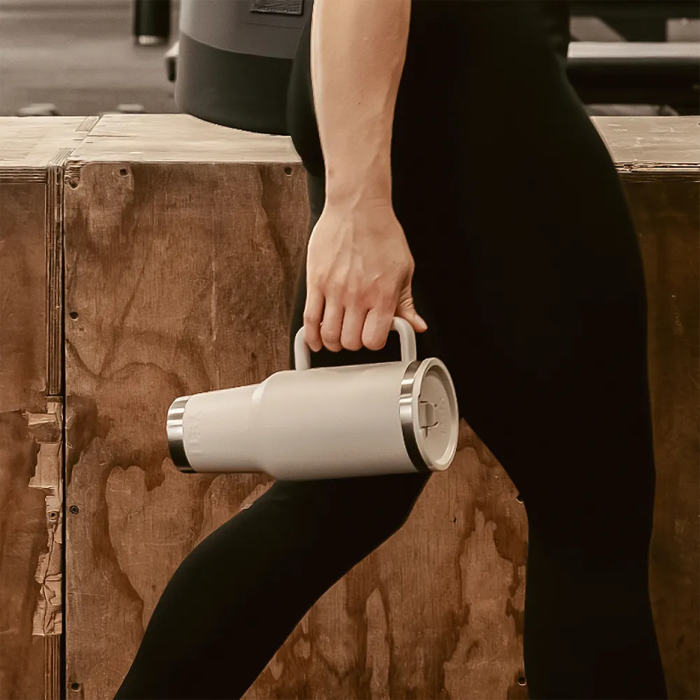 Person carrying Yeti 40 oz Travel Mug with Color Match Straw Lid by handle while walking.