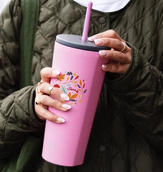 woman holding a custom printed insulated pink tumbler with straw