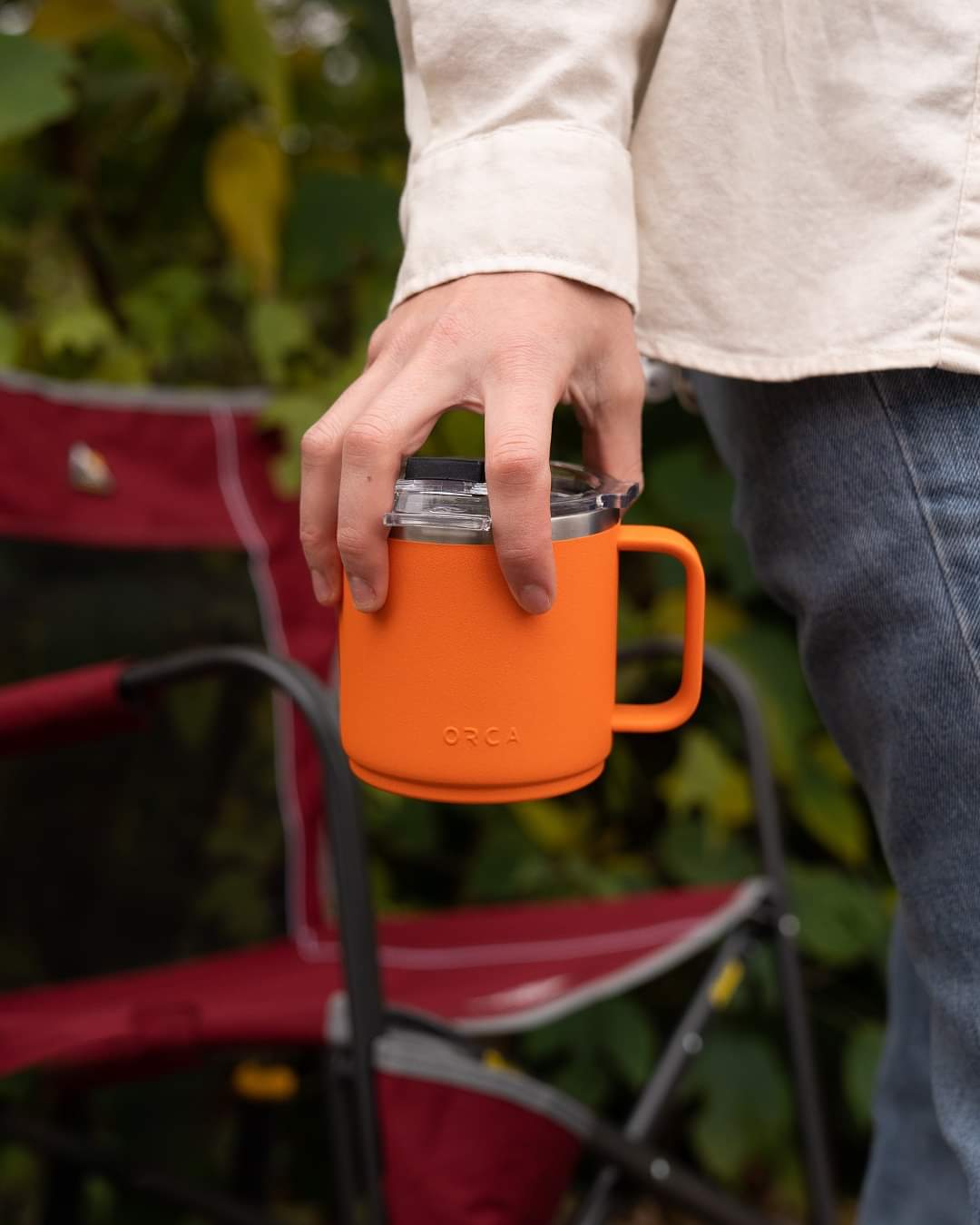 Man holding orange orca mug