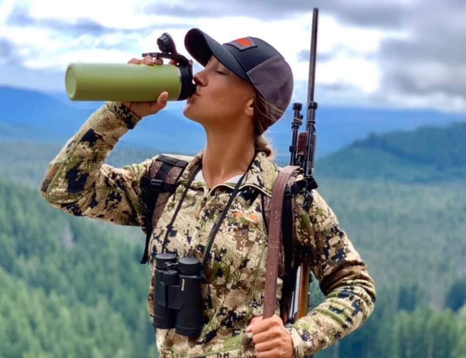 Woman drinking from green orca water bottle