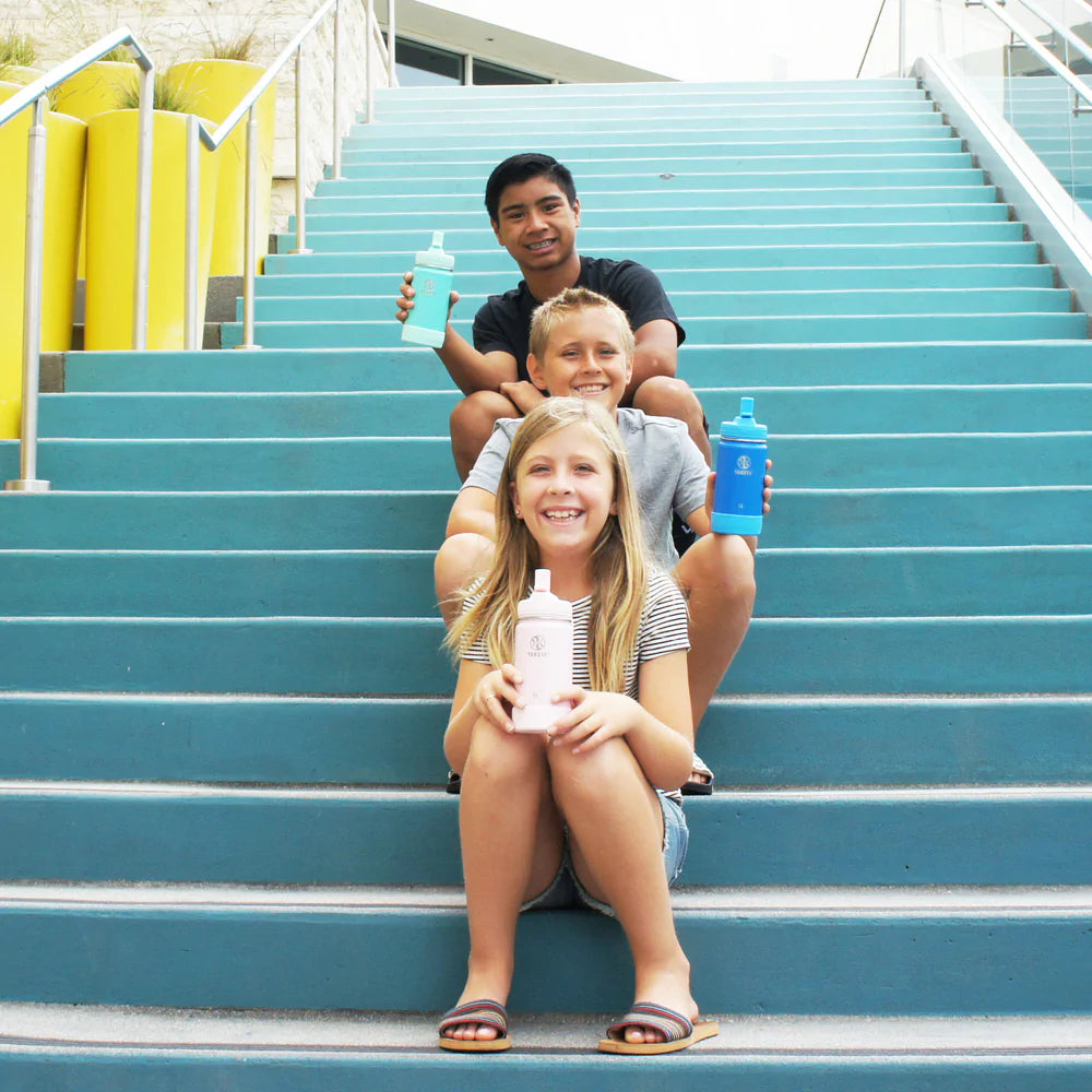 Kids sitting on steps holding Owala Kids Flip 14 oz water bottles